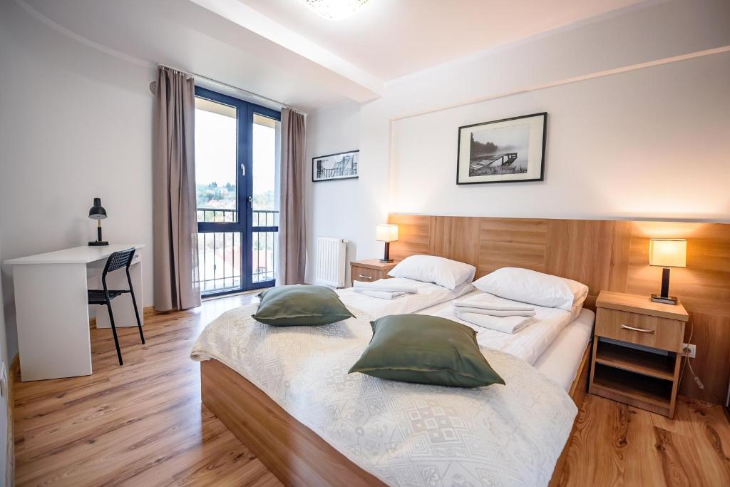 Duas camas num quarto com uma secretária e uma janela em Apartamenty Sun & Snow Centrum Krynica Zdrój em Krynica-Zdrój