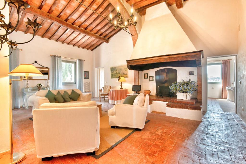salon z kanapą i kominkiem w obiekcie Appartamenti Villa La Fonte w mieście San Gimignano