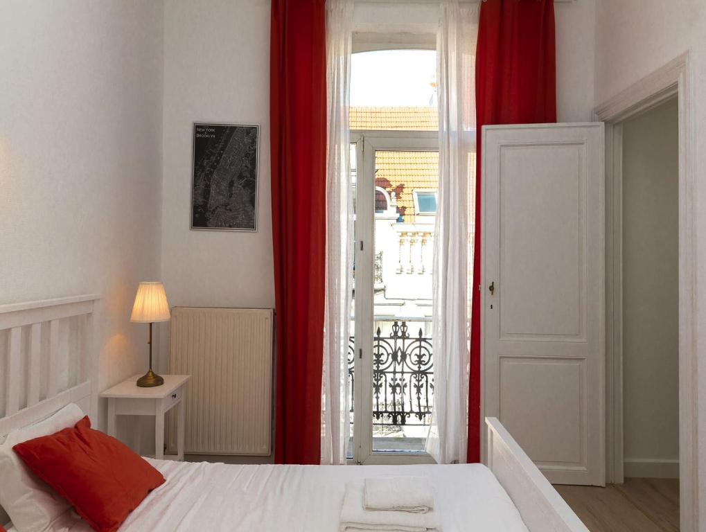 1 dormitorio con 1 cama con cortinas rojas y puerta en Apartment in Brussels, Lantsheere by Homenhancement SA en Bruselas