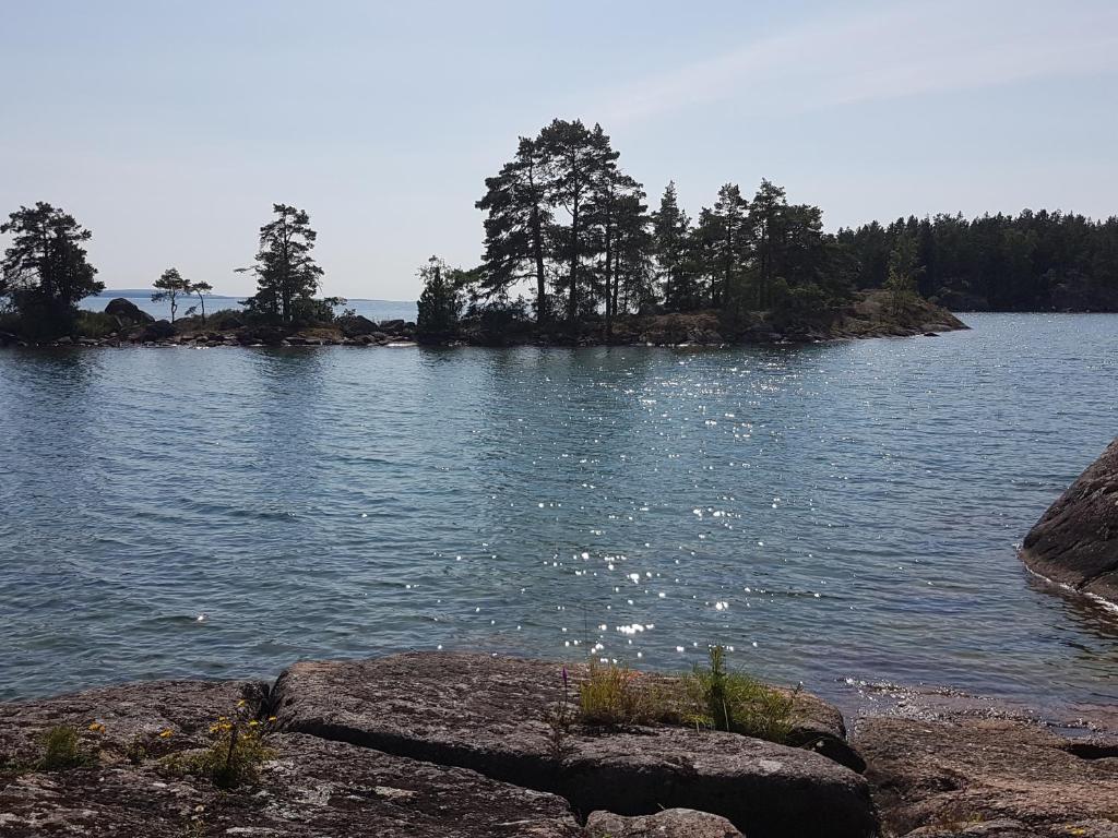 a large body of water with trees and rocks at Torpet Gårdsvägen in Hammar