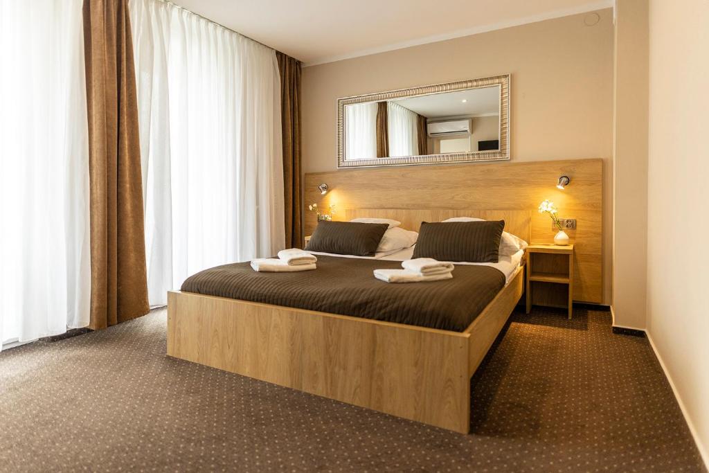 a bedroom with a large bed with a mirror on the wall at Hotel Boss in Łódź