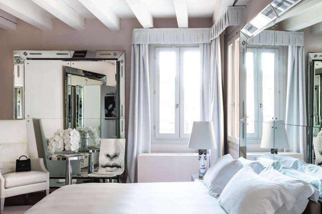 a bedroom with a bed and a mirror and a tub at Hotel Palazzina Grassi in Venice