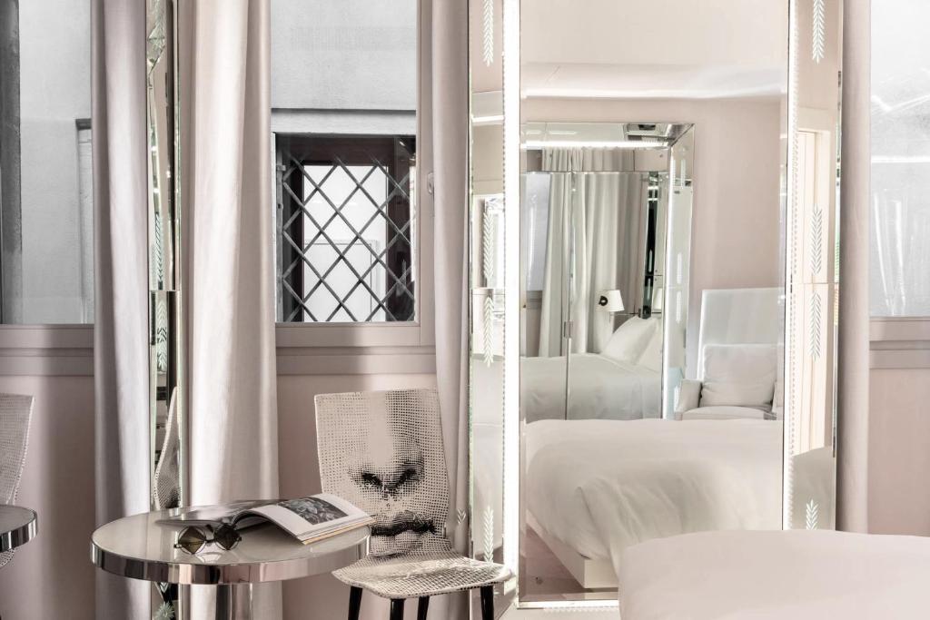 a white room with a bed and a mirror at Hotel Palazzina Grassi in Venice