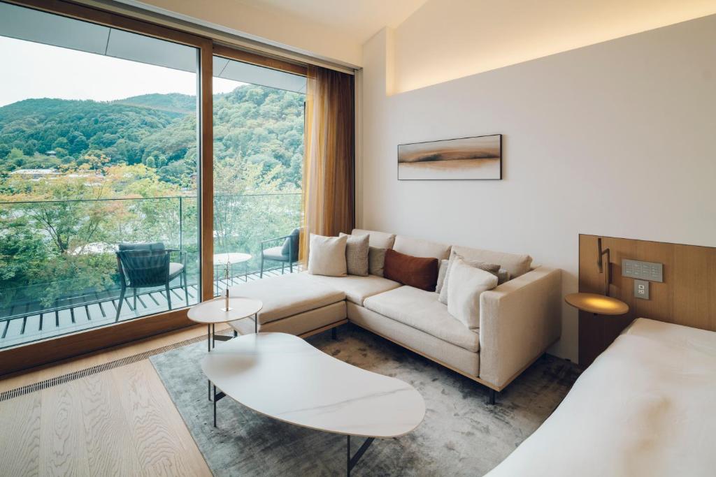 a hotel room with a couch and a large window at MUNI KYOTO by Onko Chishin in Kyoto