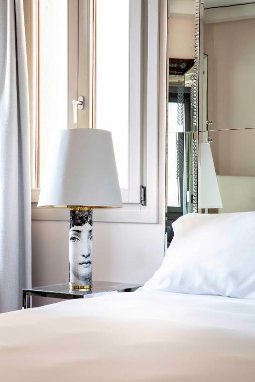 a lamp on a table next to a bed at Hotel Palazzina Grassi in Venice