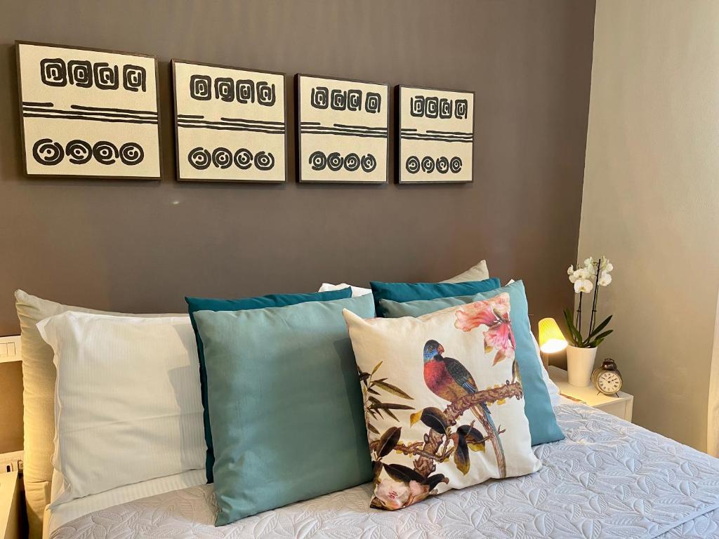 a bedroom with a bed with pillows and pictures on the wall at Villa Luminosa in Torre del Lago Puccini