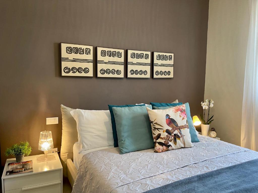 a bedroom with a bed with four pictures on the wall at Villa Luminosa in Torre del Lago Puccini