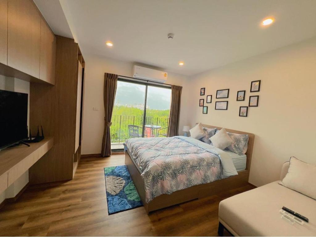 a bedroom with a bed and a tv and a window at La Habana Huahin by Ying in Hua Hin