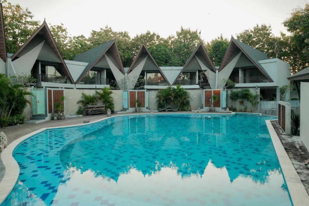 una imagen de una piscina frente a una casa en The Lavana Akatara Villa Nusa Dua, en Nusa Dua