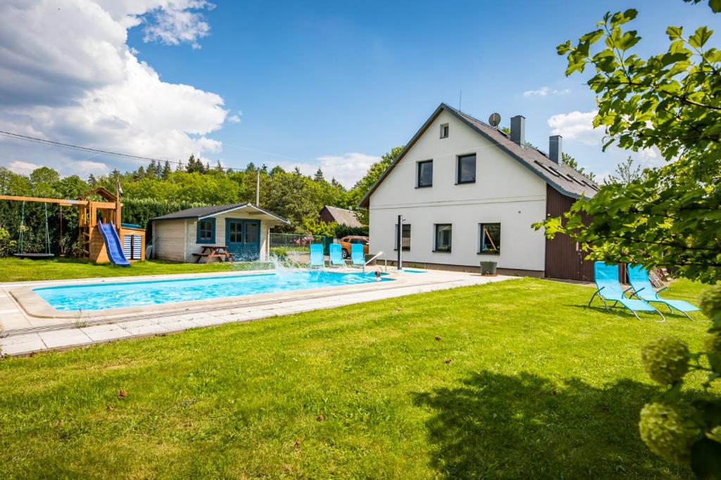 een achtertuin met een zwembad en een huis bij Vila Les Kralovstvi in Nemojov