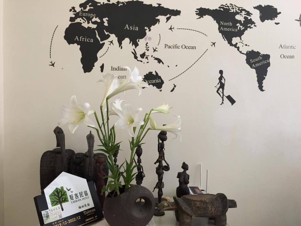 a map of the world on a wall with flowers at Guanshan Fukuda Homestay in Guanshan