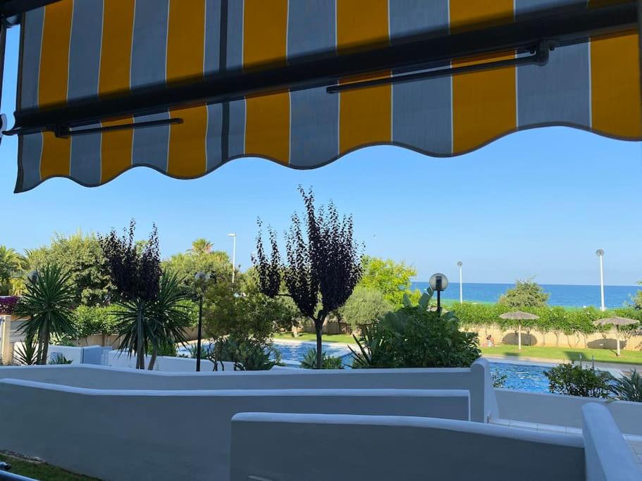 een patio met uitzicht op een zwembad bij Bajo en primera línea de playa in Alcossebre