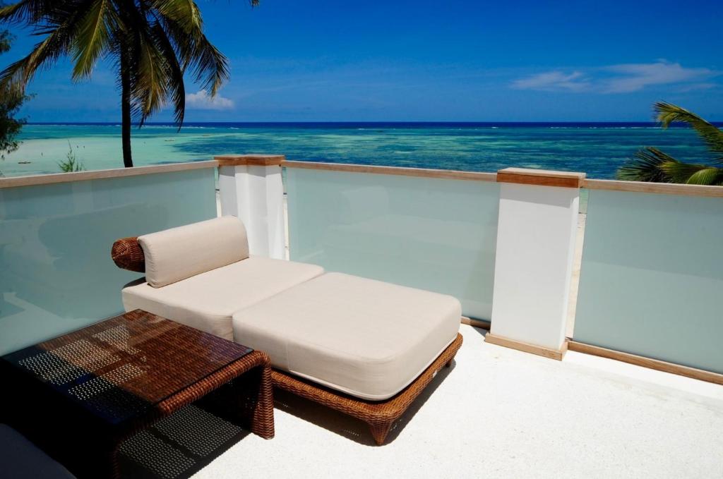 d'une chaise et d'une table blanches sur un balcon donnant sur l'océan. dans l'établissement Imani Penthouse - Private Beachfront apartment with Spectacular Ocean Views, à Kiwengwa