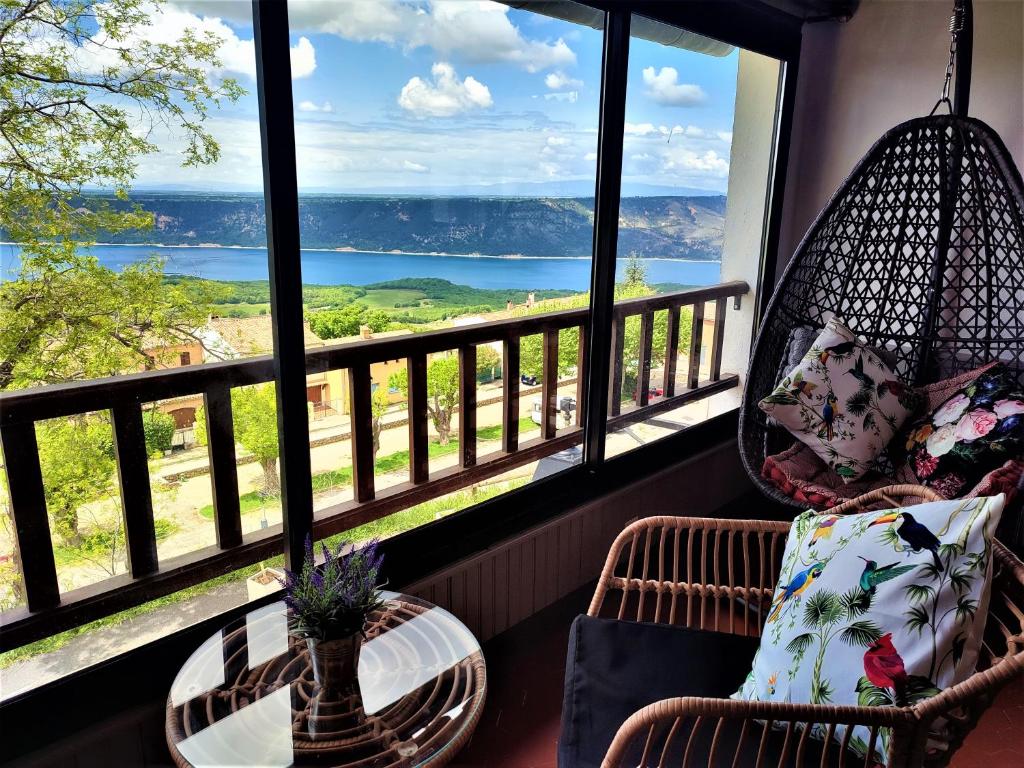a balcony with chairs and a table and a view of the ocean at Gabrielle hôtel in Aiguines