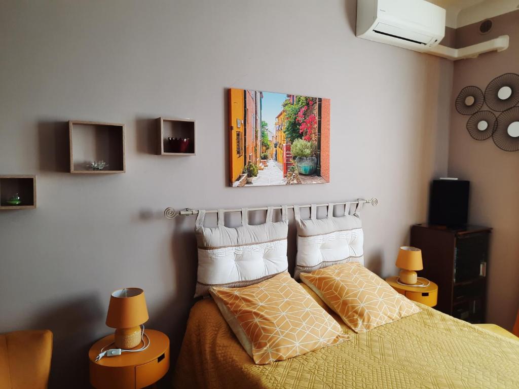 a bedroom with a bed and a painting on the wall at la chambre de CLEO in Cannes