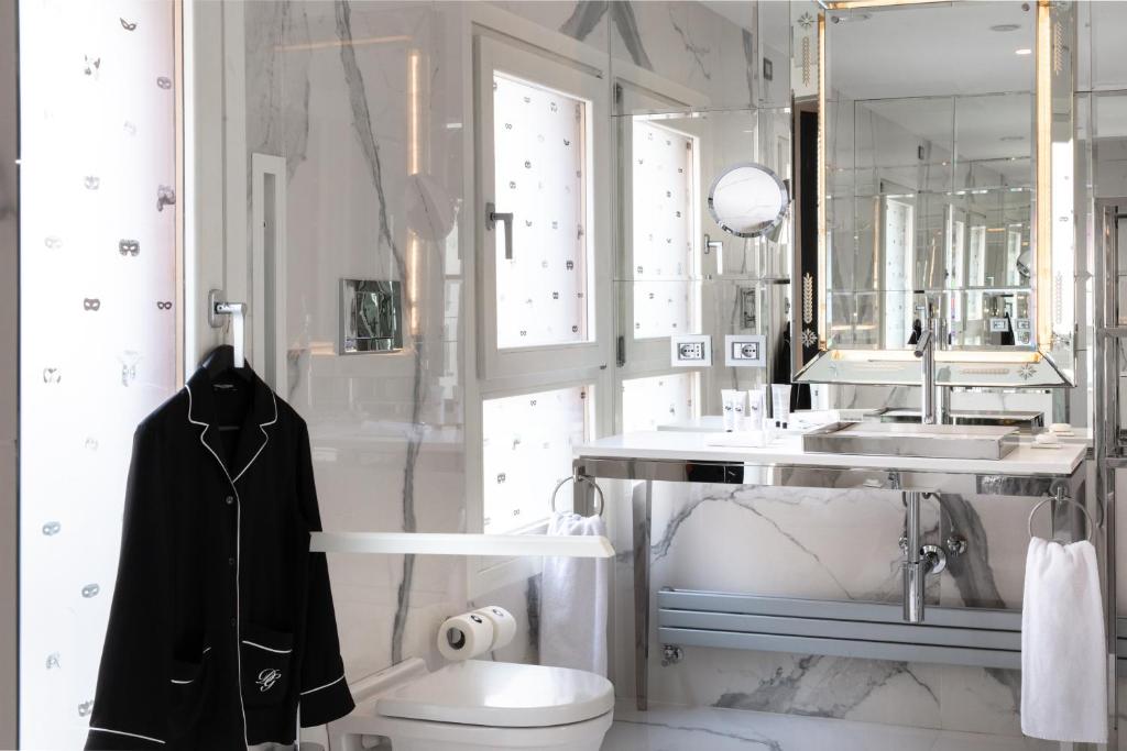 a bathroom with a sink and a toilet and a mirror at Hotel Palazzina Grassi in Venice