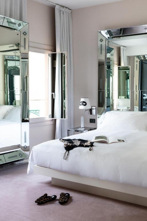 a bedroom with a white bed and two mirrors at Hotel Palazzina Grassi in Venice