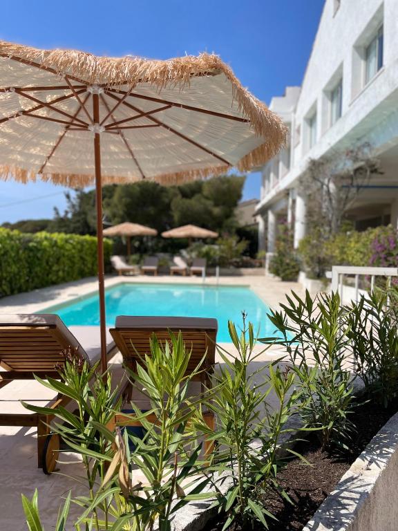 un parasol et des chaises à côté d'une piscine dans l'établissement Villa Paradis, aux Issambres