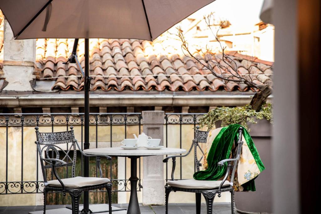 a table and chairs with an umbrella on a patio at Hotel Palazzina Grassi in Venice