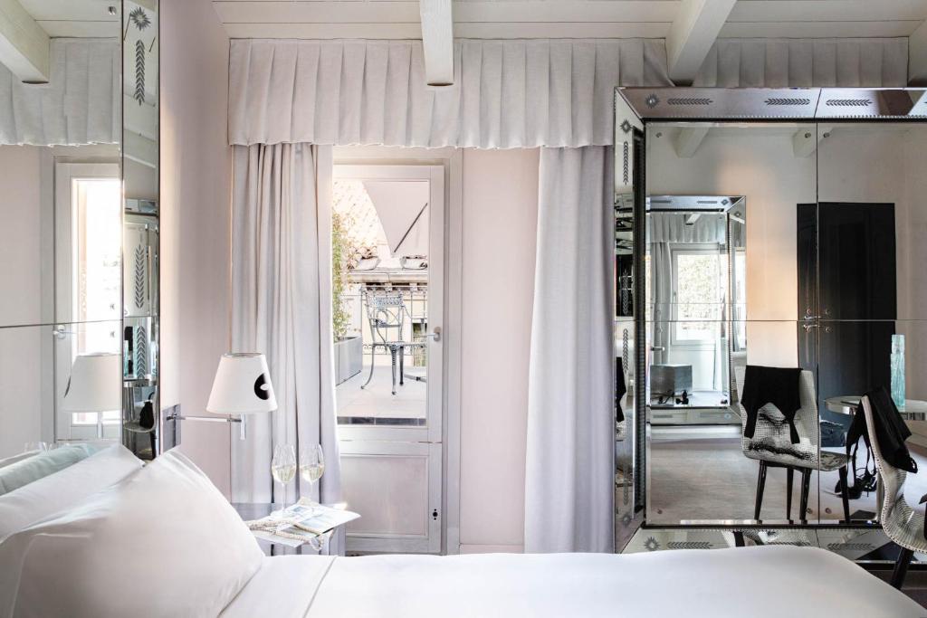 a bedroom with a white bed and a mirror at Hotel Palazzina Grassi in Venice