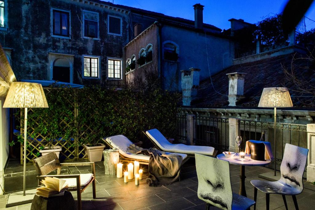 a patio with chairs and tables and two lamps at Hotel Palazzina Grassi in Venice