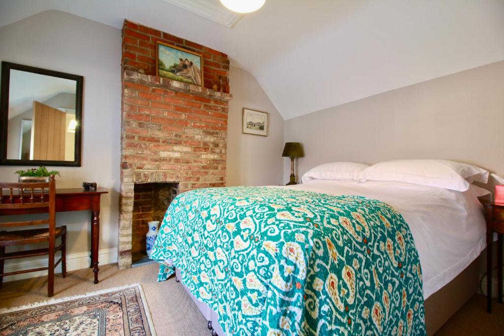 a bedroom with a bed and a fireplace at 14th century Rose cottage, Centre of Alfriston By Air Premier in Alfriston