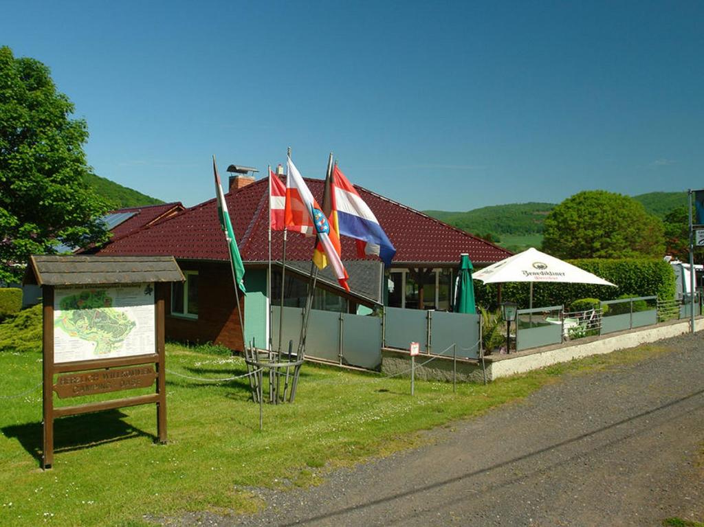 ein Gebäude mit Flaggen auf der Straßenseite in der Unterkunft Camping Oase Wahlhausen in Wahlhausen