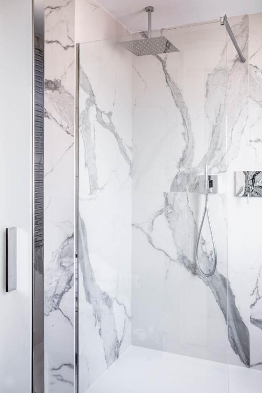 a shower in a bathroom with marble walls at Hotel Palazzina Grassi in Venice