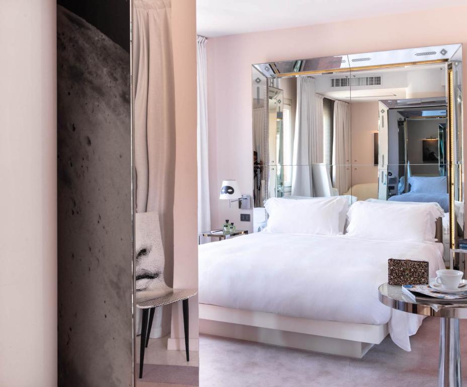 a bedroom with a large white bed and a mirror at Hotel Palazzina Grassi in Venice