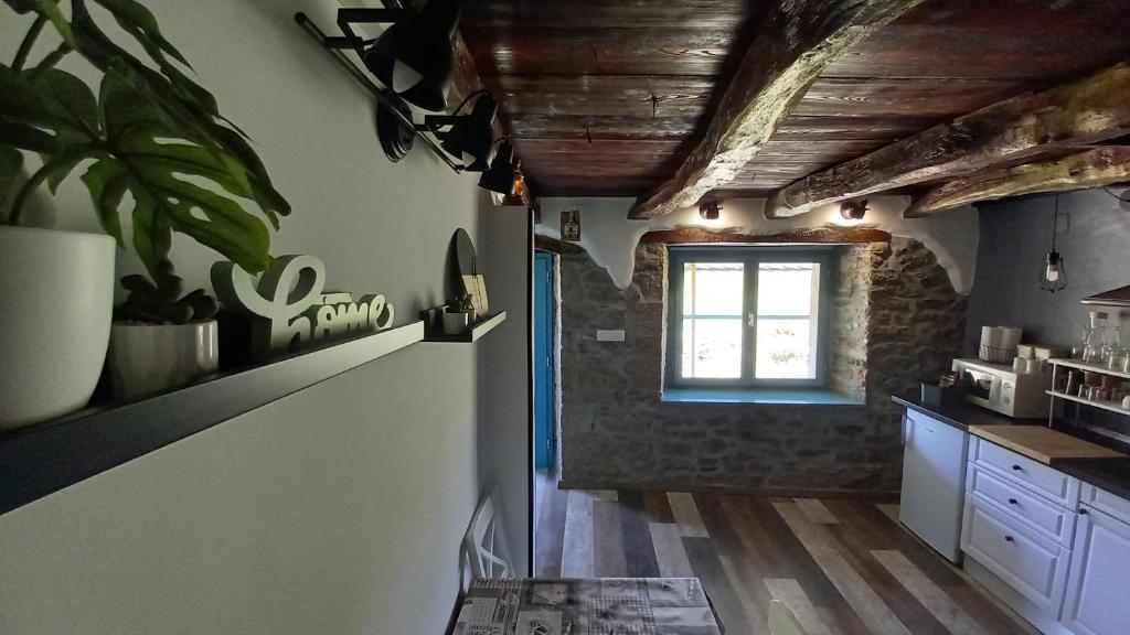una cocina con techos de madera y una ventana en House Mlun, en Buzet