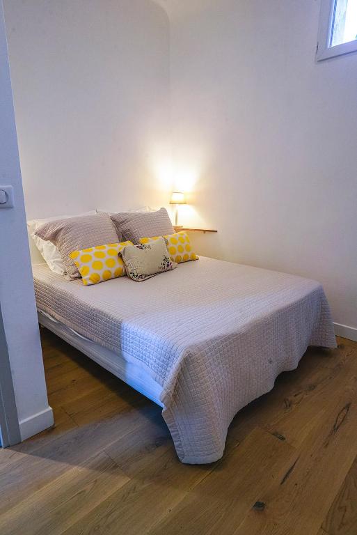 a bedroom with a bed with yellow pillows on it at Hotel Relais Du Postillon in Antibes