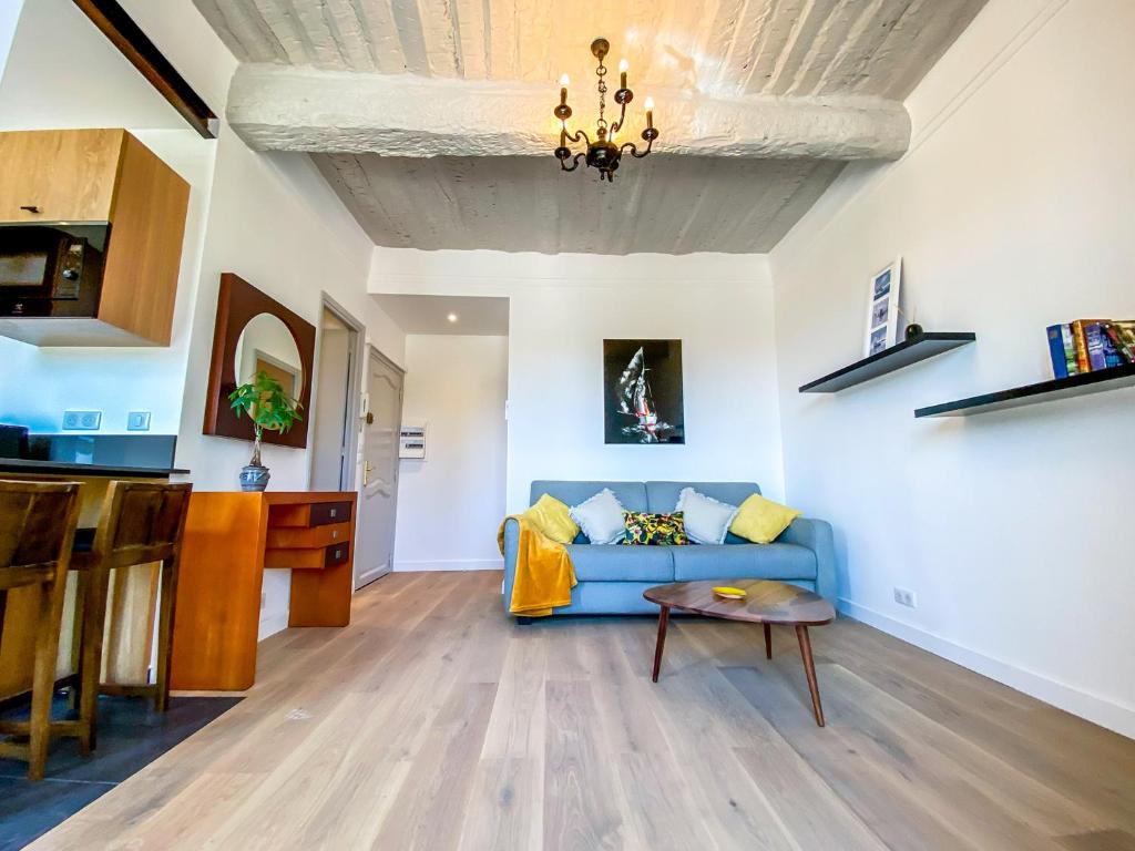 a living room with a blue couch and a table at Hotel Relais Du Postillon in Antibes