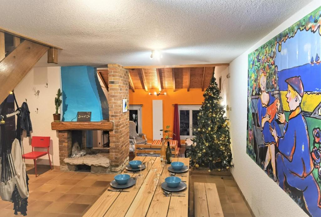 una sala de estar con un árbol de Navidad y una chimenea en CHEZ INES - Un lieu de vie en Arbois 2 à 14 personnes, en Arbois