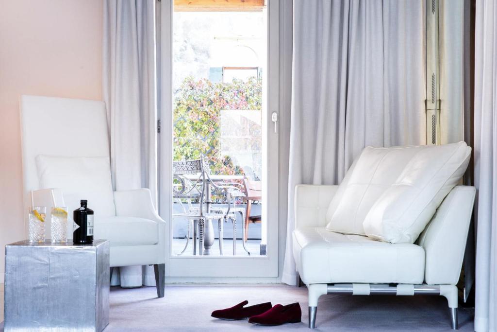 a living room with two white chairs and a table at Hotel Palazzina Grassi in Venice