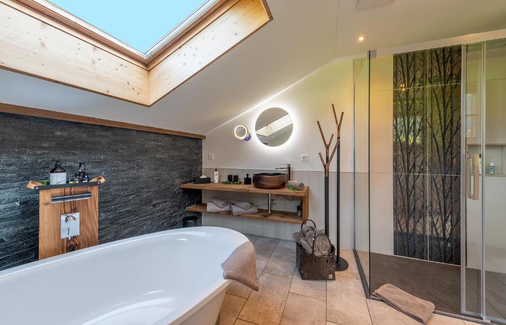 a bathroom with a tub and a glass shower at SALZANO Apartments in Interlaken