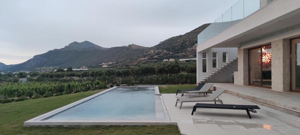a house with a swimming pool with mountains in the background at Casa le Cicale in Falasarna