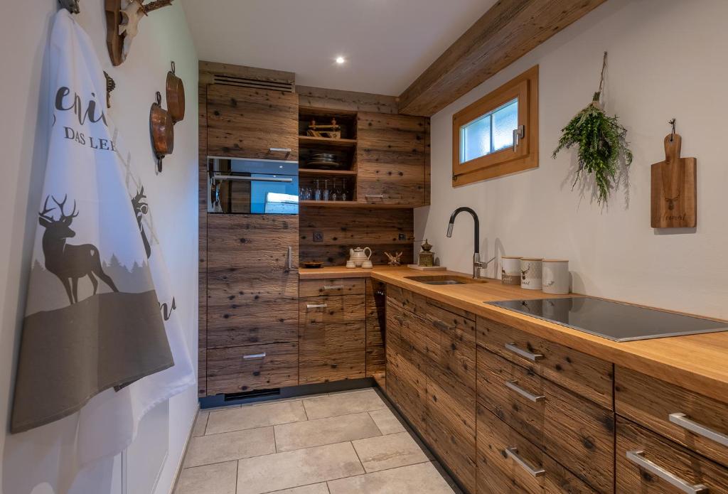 a kitchen with wooden cabinets and a sink at SALZANO Apartments in Interlaken