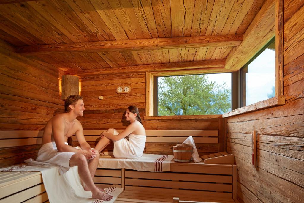 a man and woman sitting in a sauna at SALZANO Apartments in Interlaken