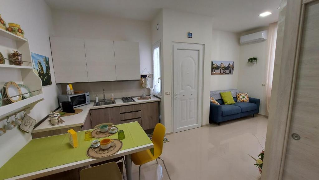 een keuken en een woonkamer met een tafel en een bank bij Casetta Mia in Monopoli