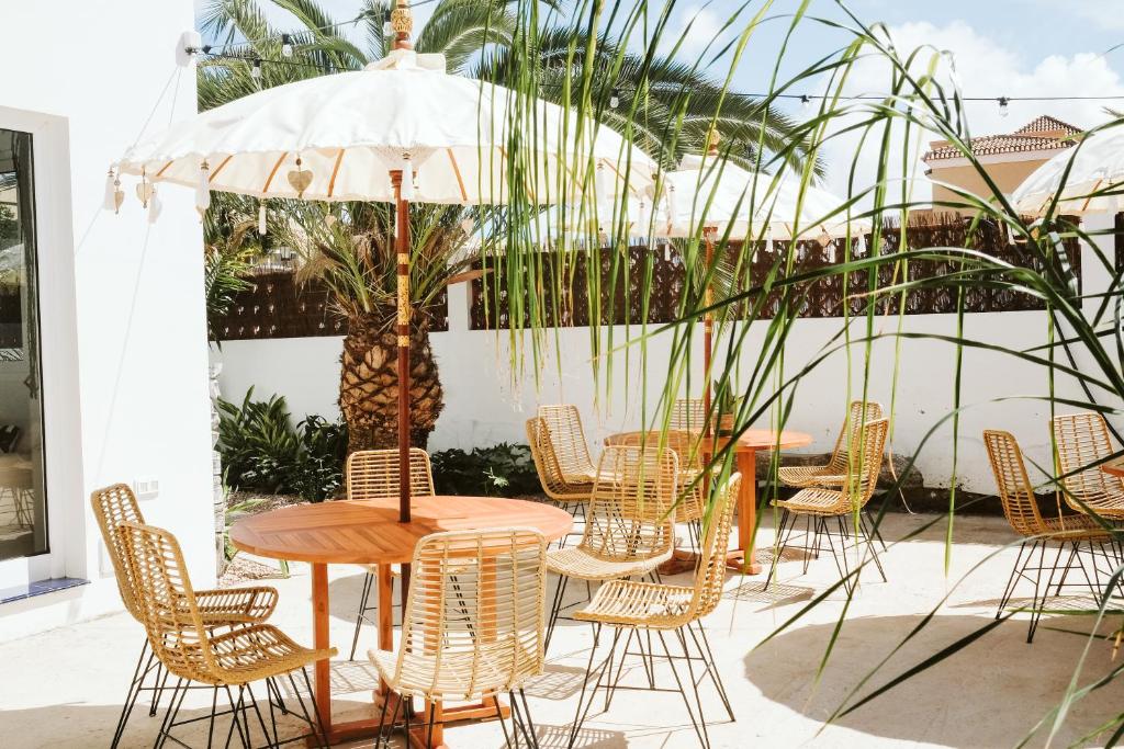 a table with chairs and an umbrella on a patio at Dreamsea Surf House Fuerteventura in Corralejo