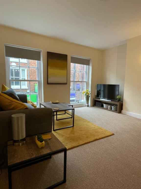 a living room with a couch and a tv at Flat 1 Chestergate in Macclesfield