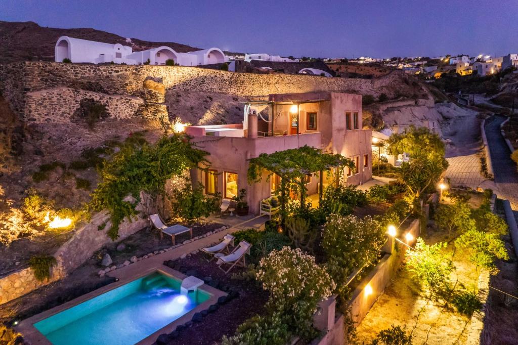an aerial view of a house with a swimming pool at night at AURORA VILLA by K&K in Oia