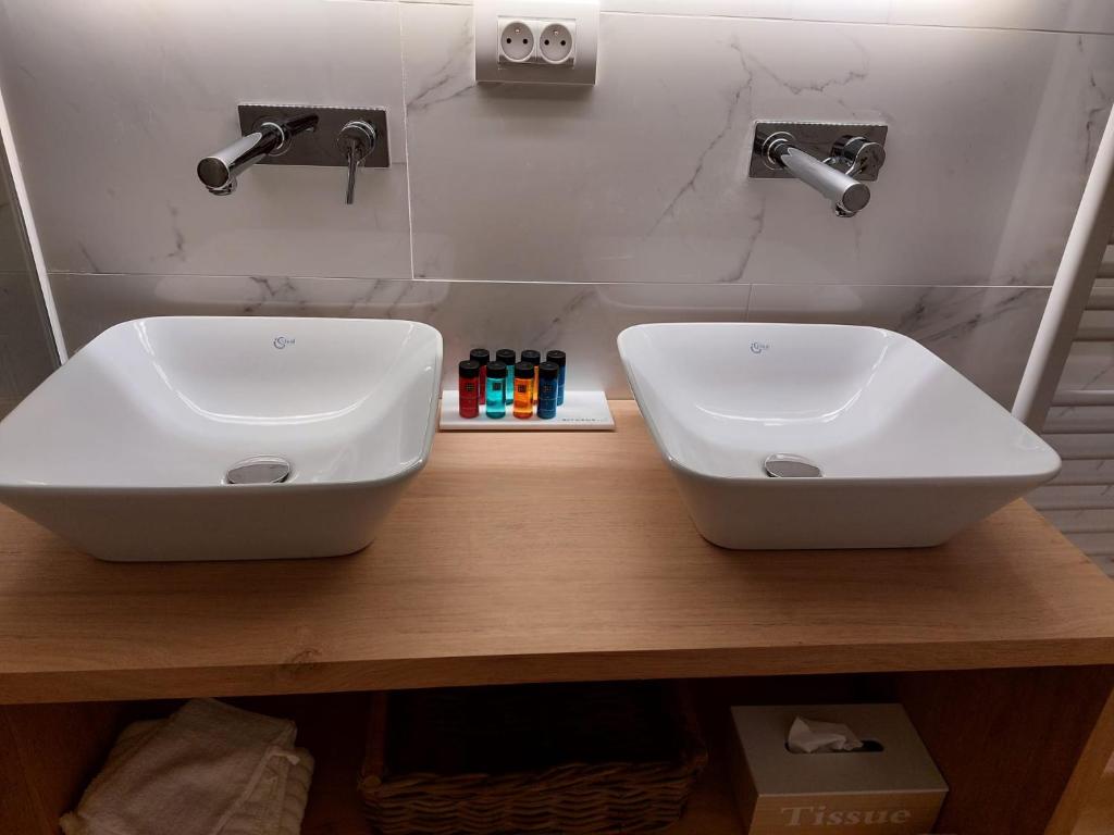 two white sinks on a wooden counter in a bathroom at St-Georges IV in Ieper