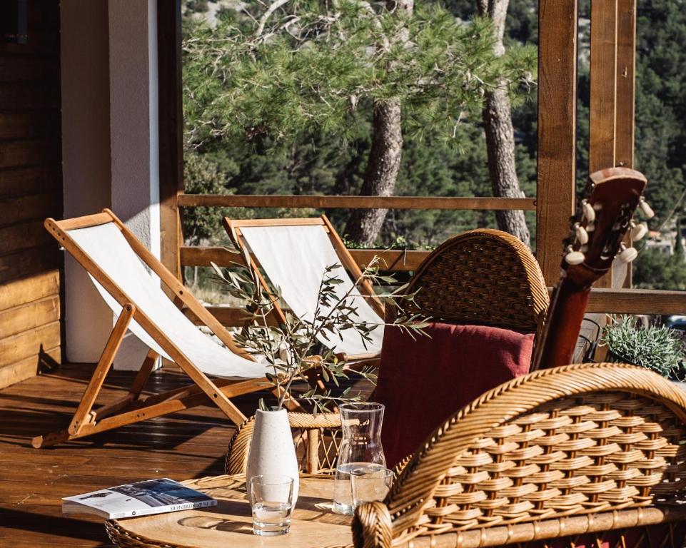 un patio con mesa y sillas en un porche en Nature House with a wooden porch - Pasika, house Tonka en Pučišća