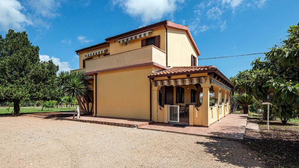 una pequeña casa amarilla sentada en la parte superior de una entrada en Welcomely - Guesthouse Kadossene Alghero en Alghero