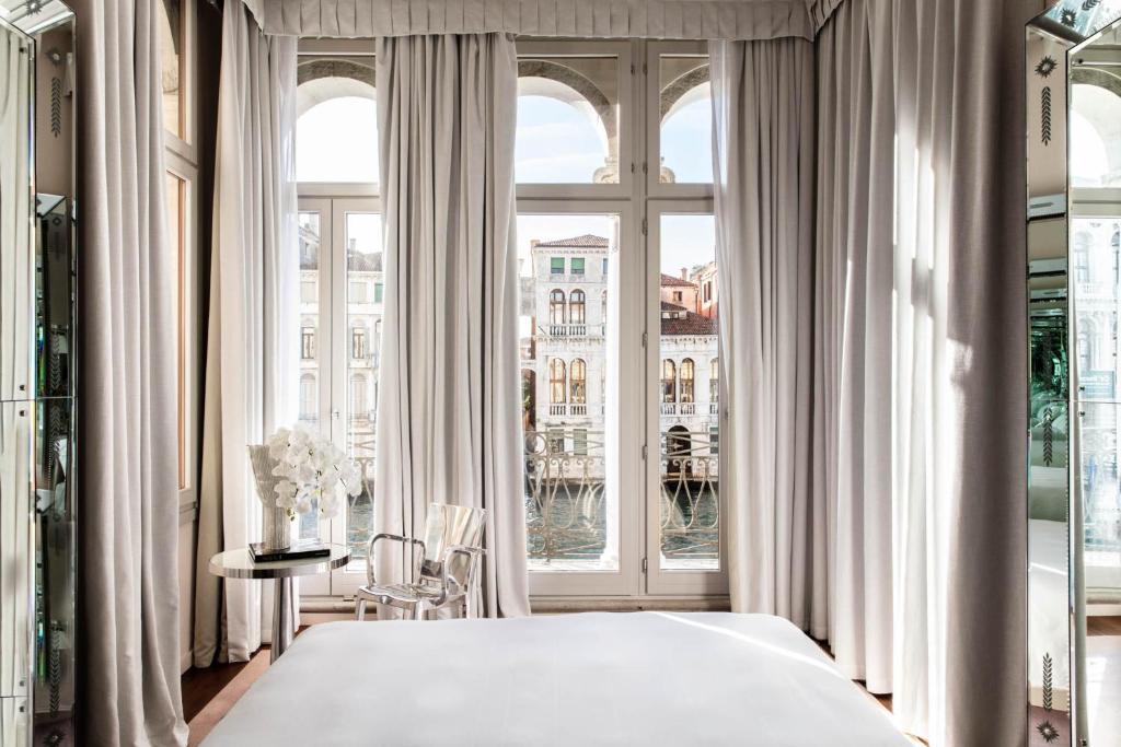 a bedroom with a bed and a large window at Hotel Palazzina Grassi in Venice