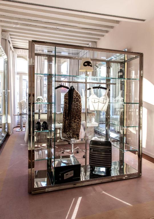 a glass display case in a room with a chair at Hotel Palazzina Grassi in Venice