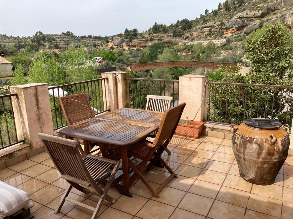 Una mesa y sillas de madera en un patio con vista. en Cal Roig, en Margalef