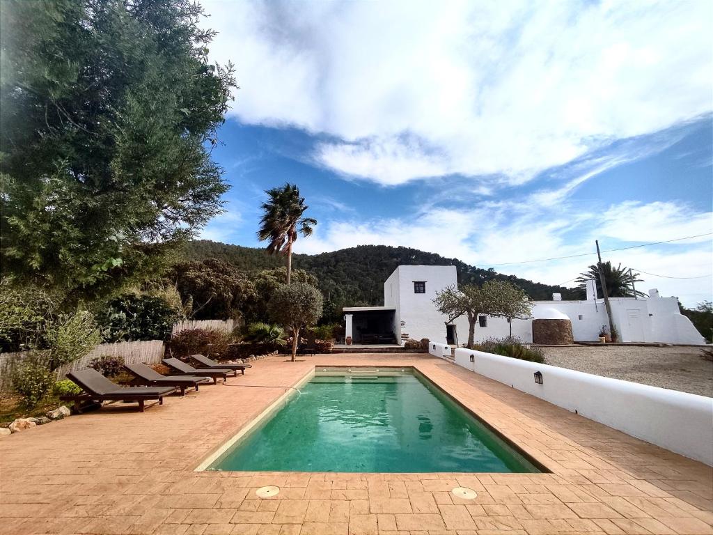 een zwembad in een tuin met stoelen en een huis bij Can Pep Frit in Ibiza-stad