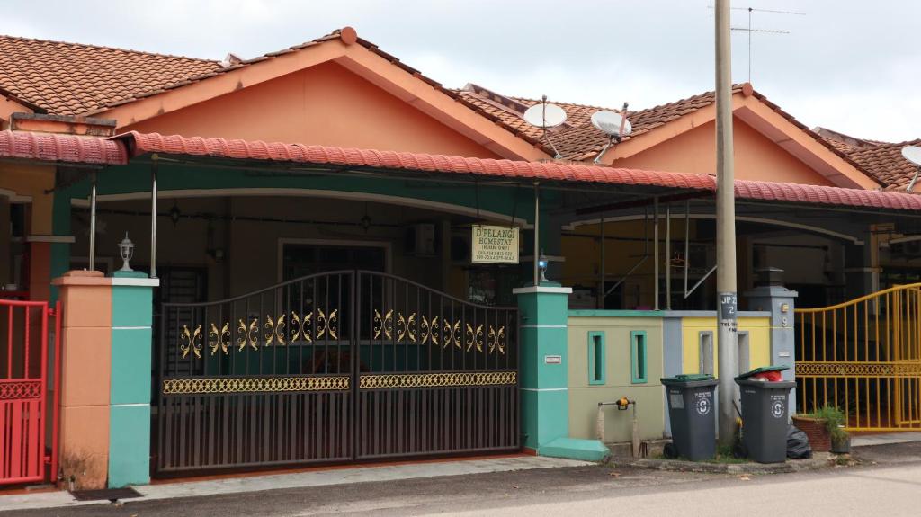 uma casa com um portão em frente em D' Pelangi Homestay Kluang em Keluang